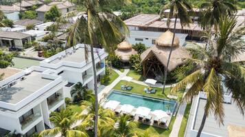 Um resort com piscina, palmeiras e edifícios modernos.