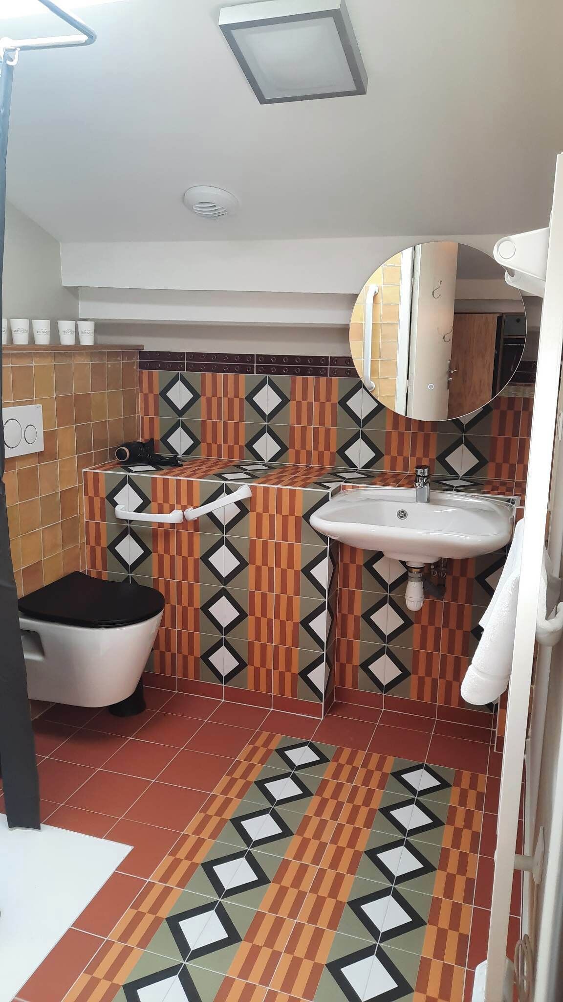A bathroom with a toilet, sink, and shower area.