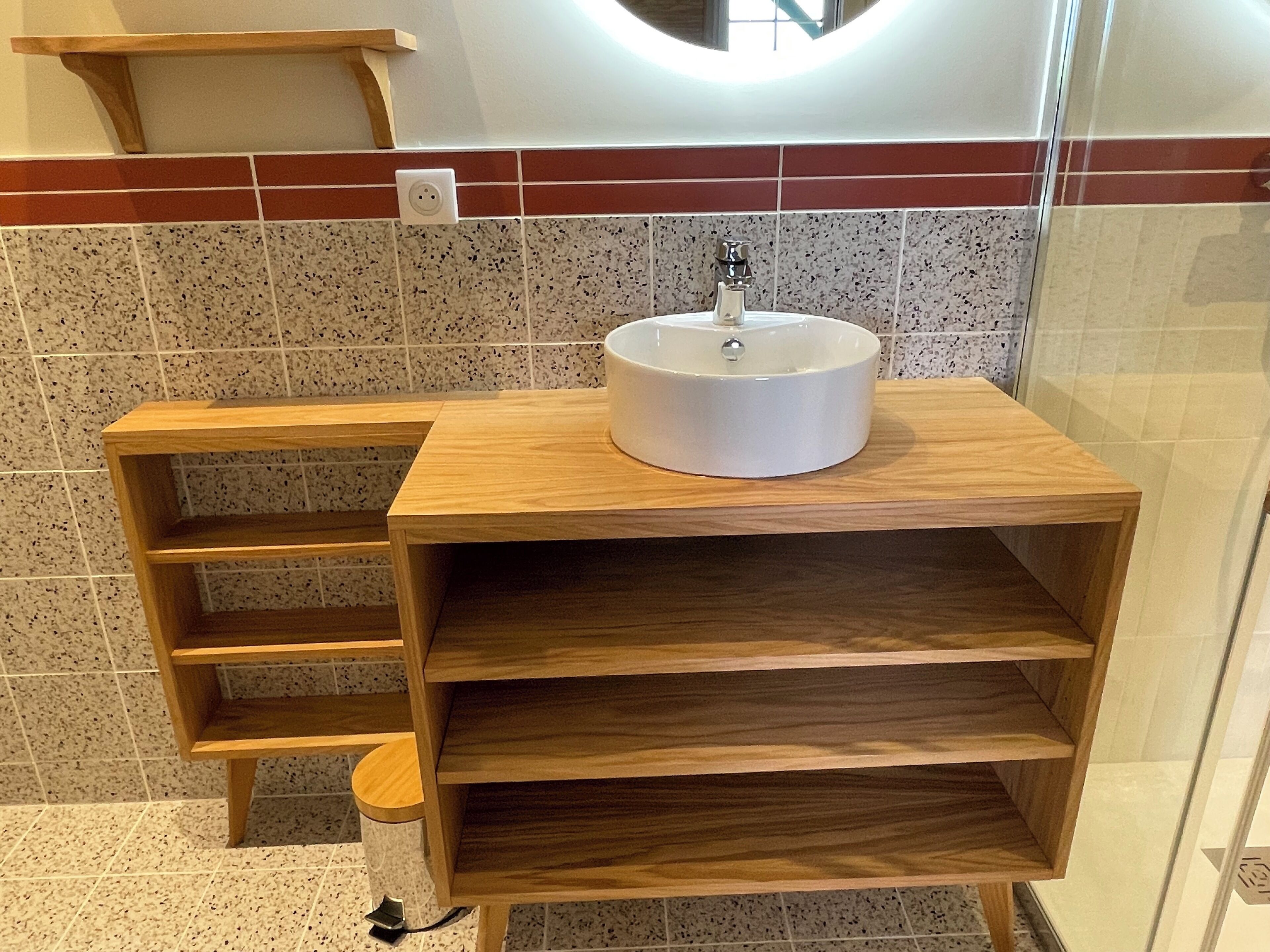 A bathroom with a wooden vanity, a sink, and a towel rack.