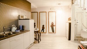 Una cuina moderna amb un respatller de fusta, un rentapeus i una zona de menjador amb taula i cadires.