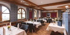 A restaurant with wooden beams, arched windows, and tables set for dining. - Landhotel Edelfinger Hof (Bad Mergentheim)