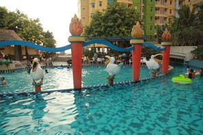 A swimming pool with decorative flamingo statues and a blue border. - Modern Studio Grand Serpong Apartment By Travelio (Tangerang)
