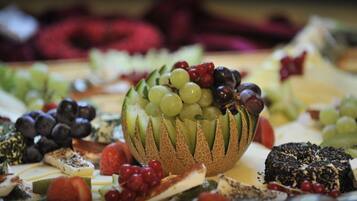 Eine Platte mit Obst und Käse, darunter Trauben, Beeren und verschiedene Käsesorten.