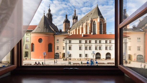 A view of a historic building with multiple towers and a red-roofed structure.