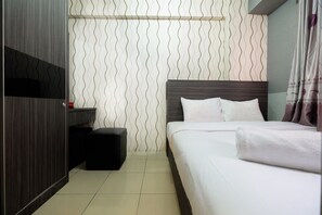 A modern hotel room with a neatly made bed, a small bedside table, and a wall with a wavy pattern. - Monochrome Style 2 Bedrooms at Kalibata City Apartment By Travelio (Jakarta)