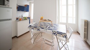 Una cocina con una mesa de comedor, sillas y un refrigerador.