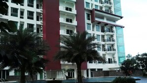A multi-story hotel with a modern design, featuring balconies and a swimming pool area. - 2 Bedrooms Woodland Park Apartment by Travelio (Jakarta)