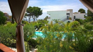 Vista de una piscina rodeada de exuberante vegetación y edificios modernos.