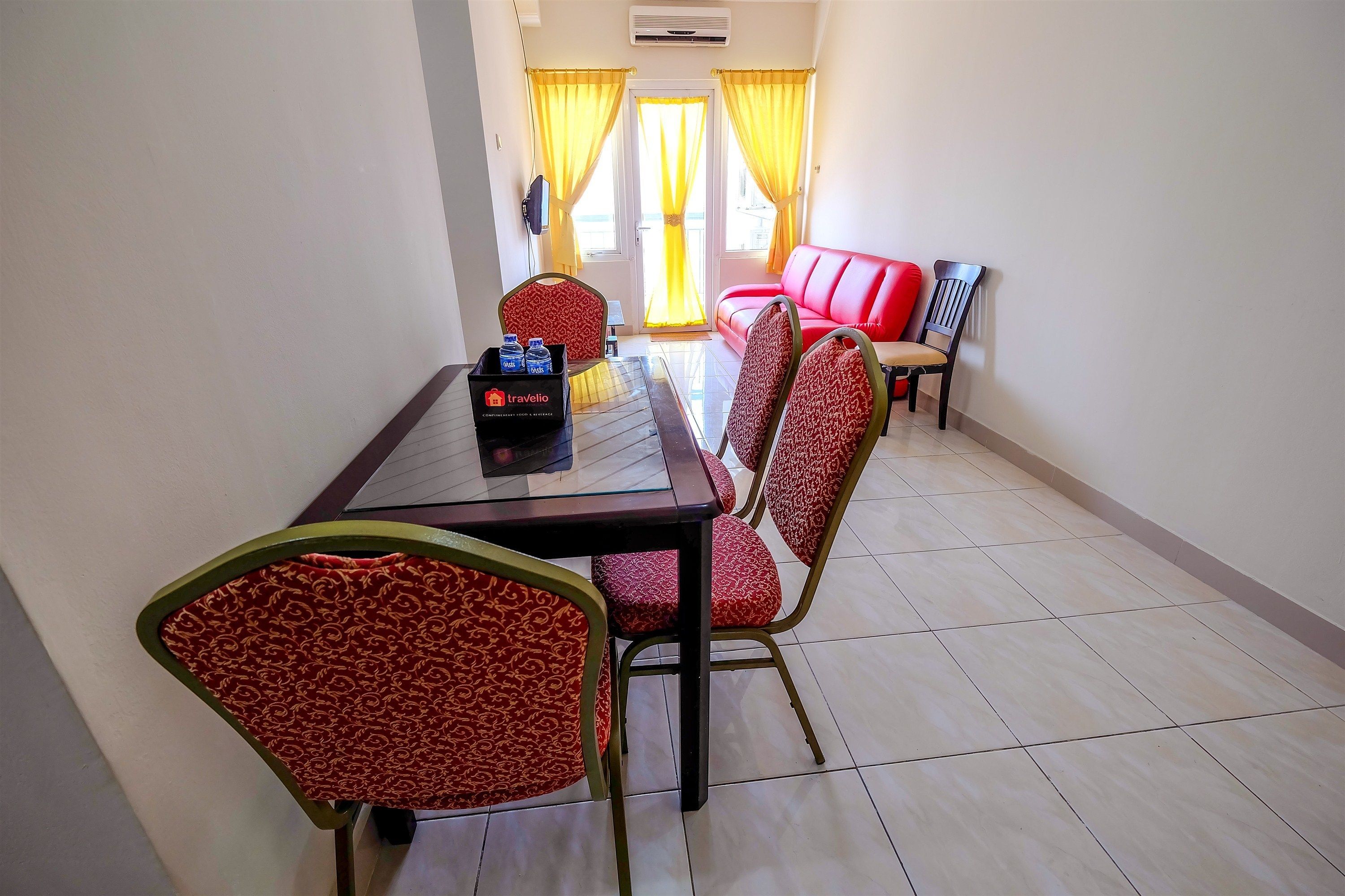 Un coin repas avec une table, des chaises et un canapé rouge.