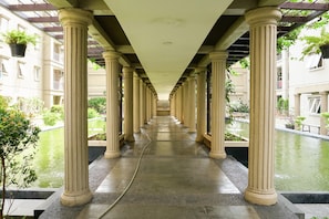 Columns support a flat ceiling in this elegant corridor, flanked by water features and lush greenery.