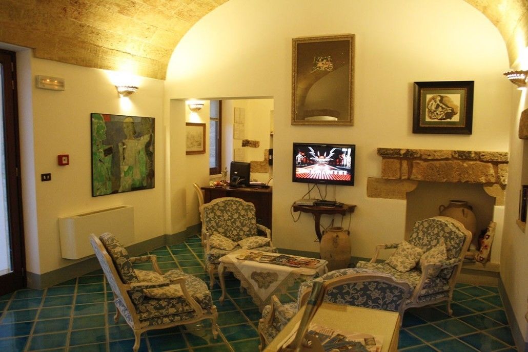 Una sala de estar acogedora con sillones estampados, un televisor y obras de arte en las paredes.
