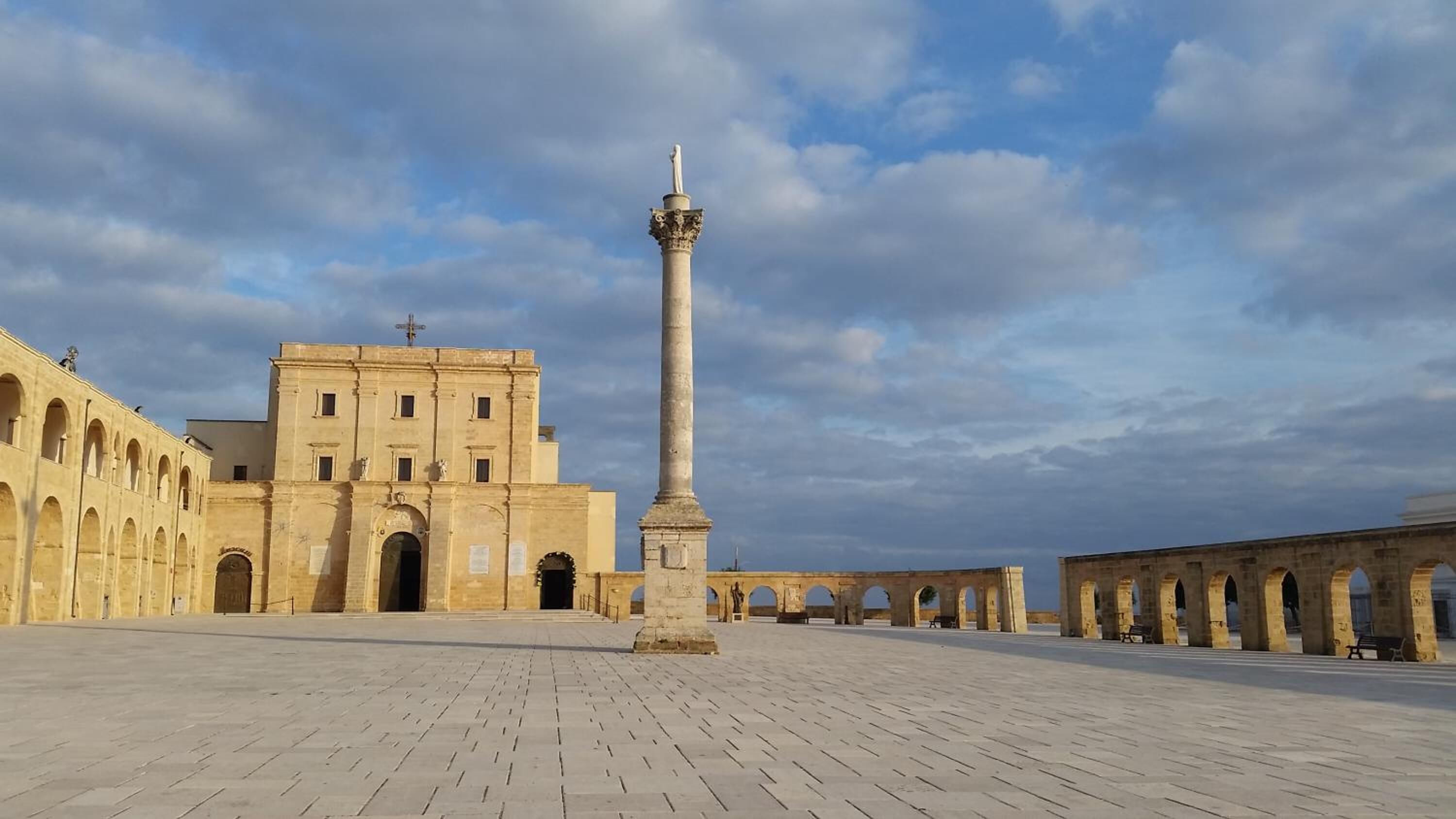 A historical building with a tall column and arches.