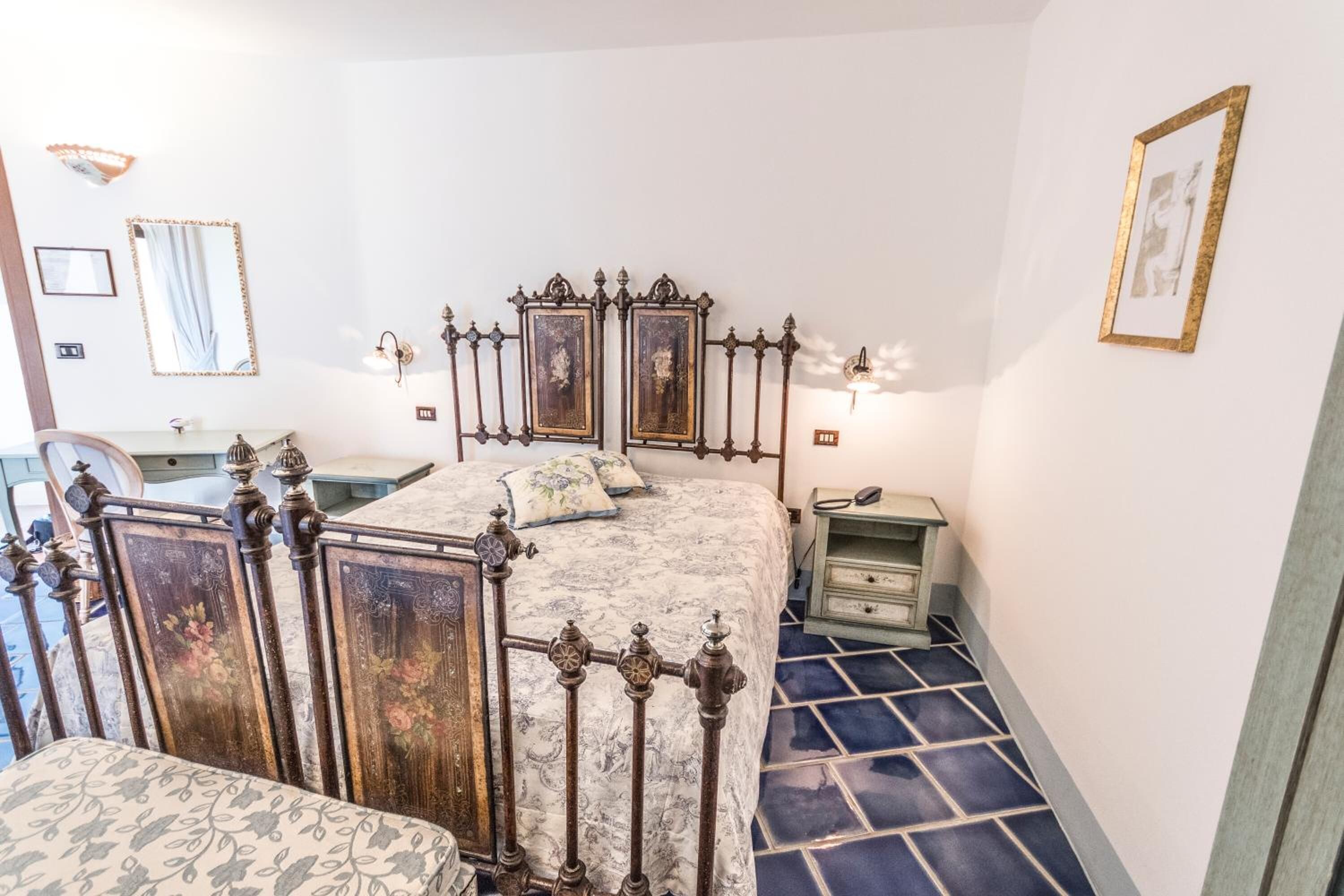 A bedroom with a bed, a dresser, a nightstand, and a mirror.