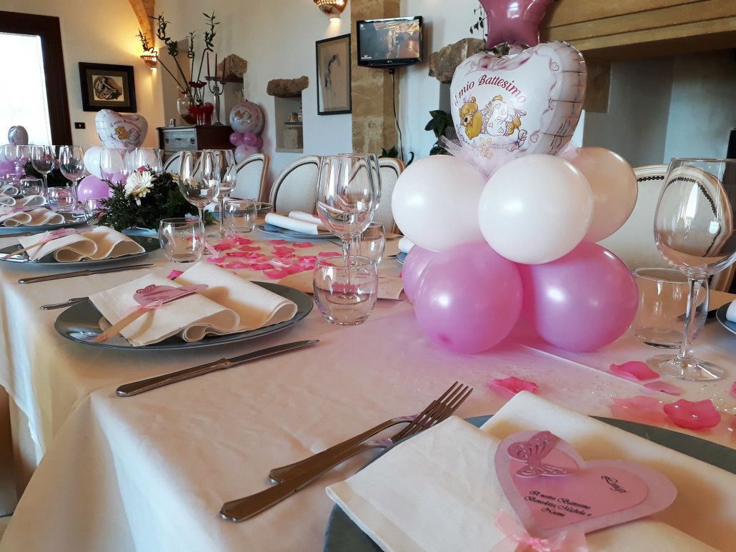 Ein Tisch festlich gedeckt, mit einem pink-weißen Farbkonzept, inklusive Luftballons und herzförmigen Servietten.