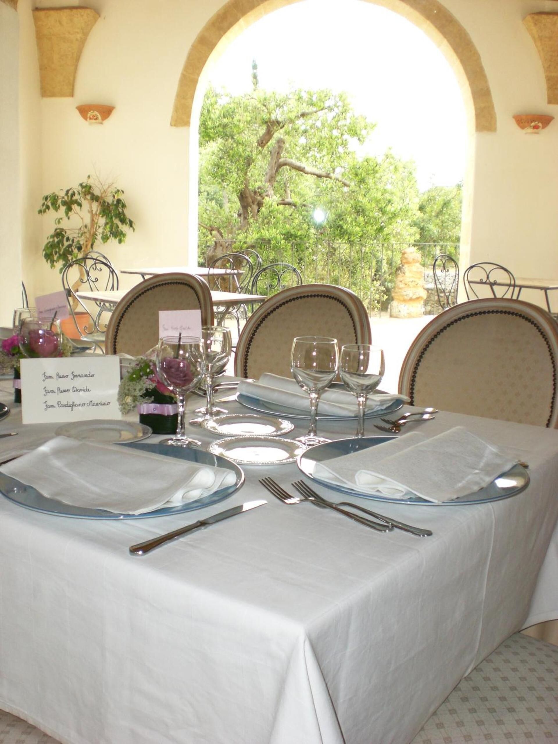 A table set for four with a view of greenery outside.