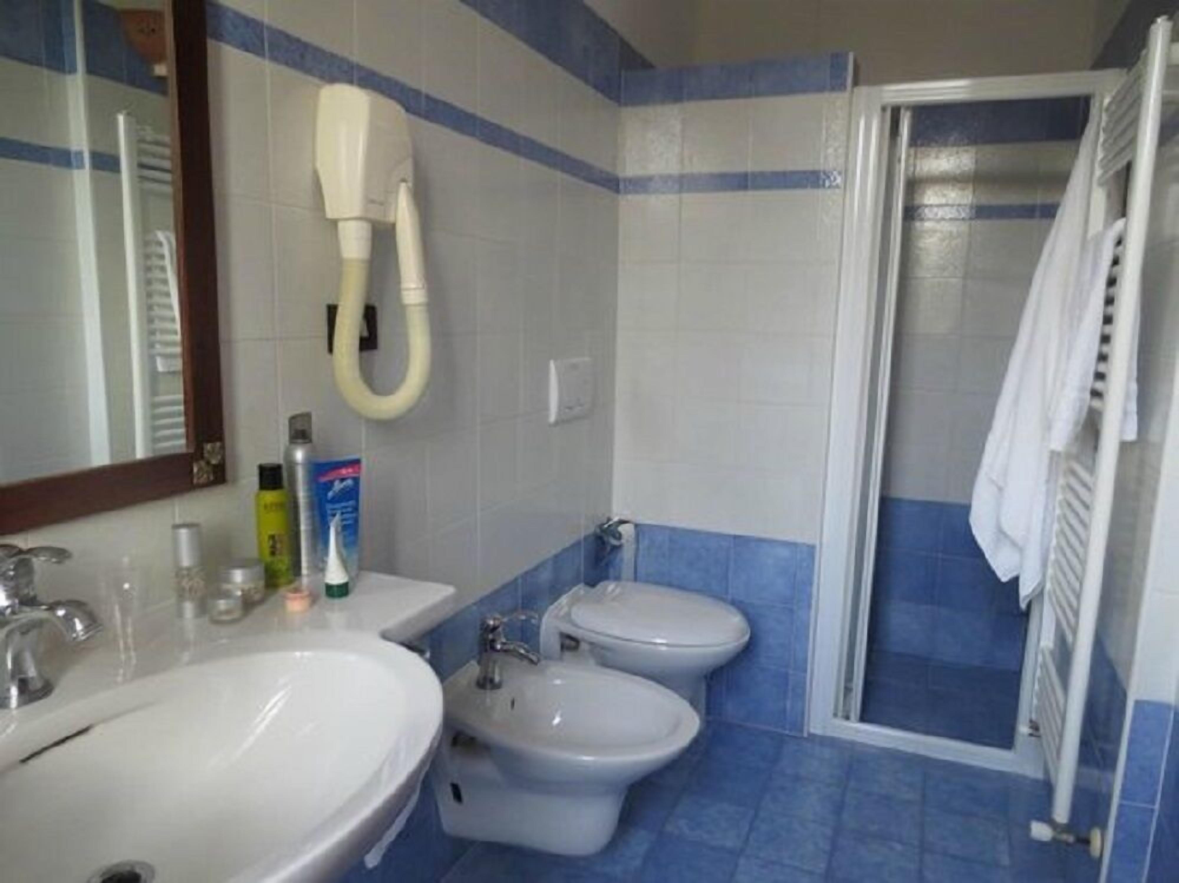 Une salle de bain avec deux lavabos, un bidet et une douche.