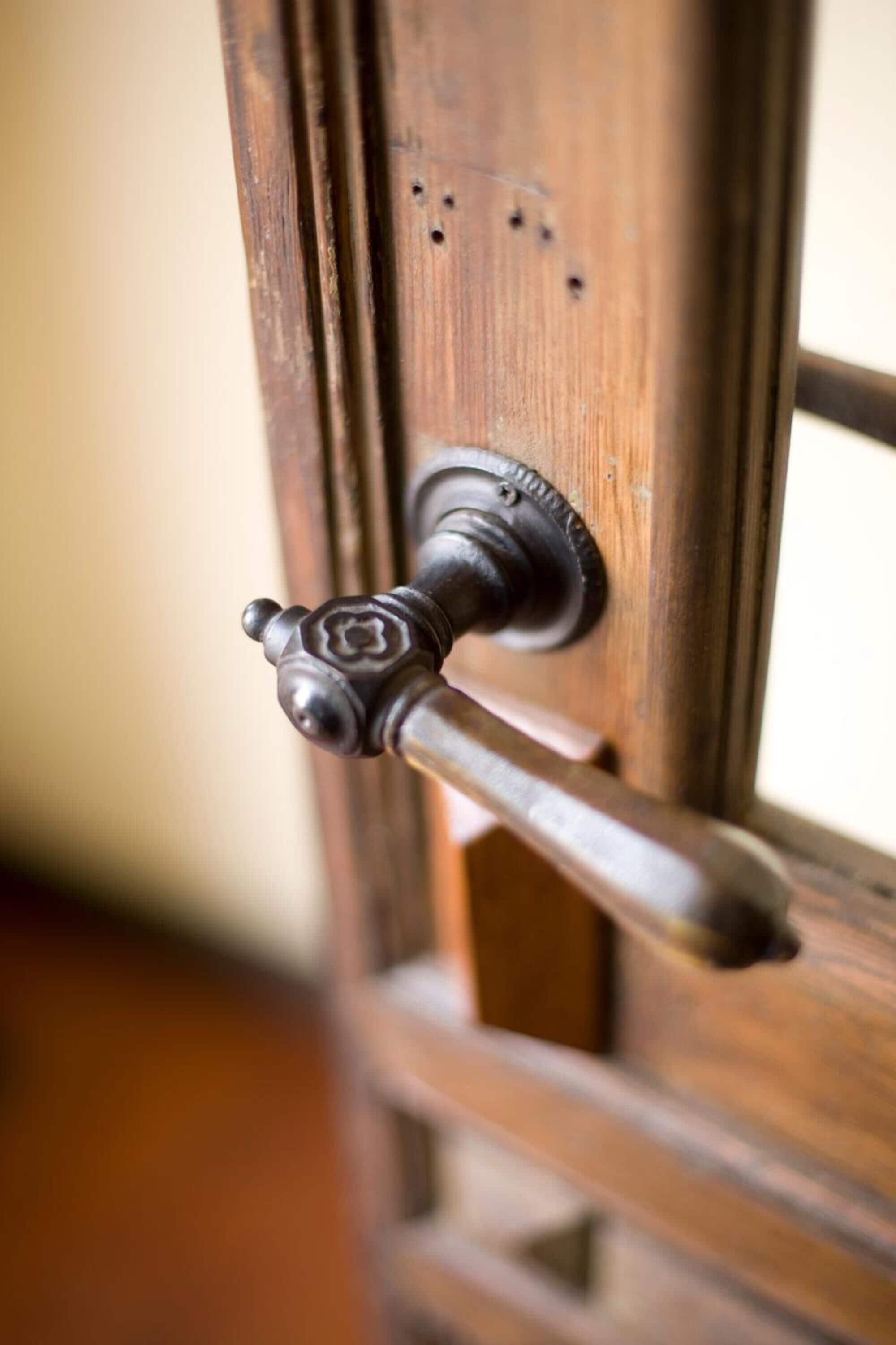 Una puerta de madera con una manija de estilo antiguo y una cerradura.