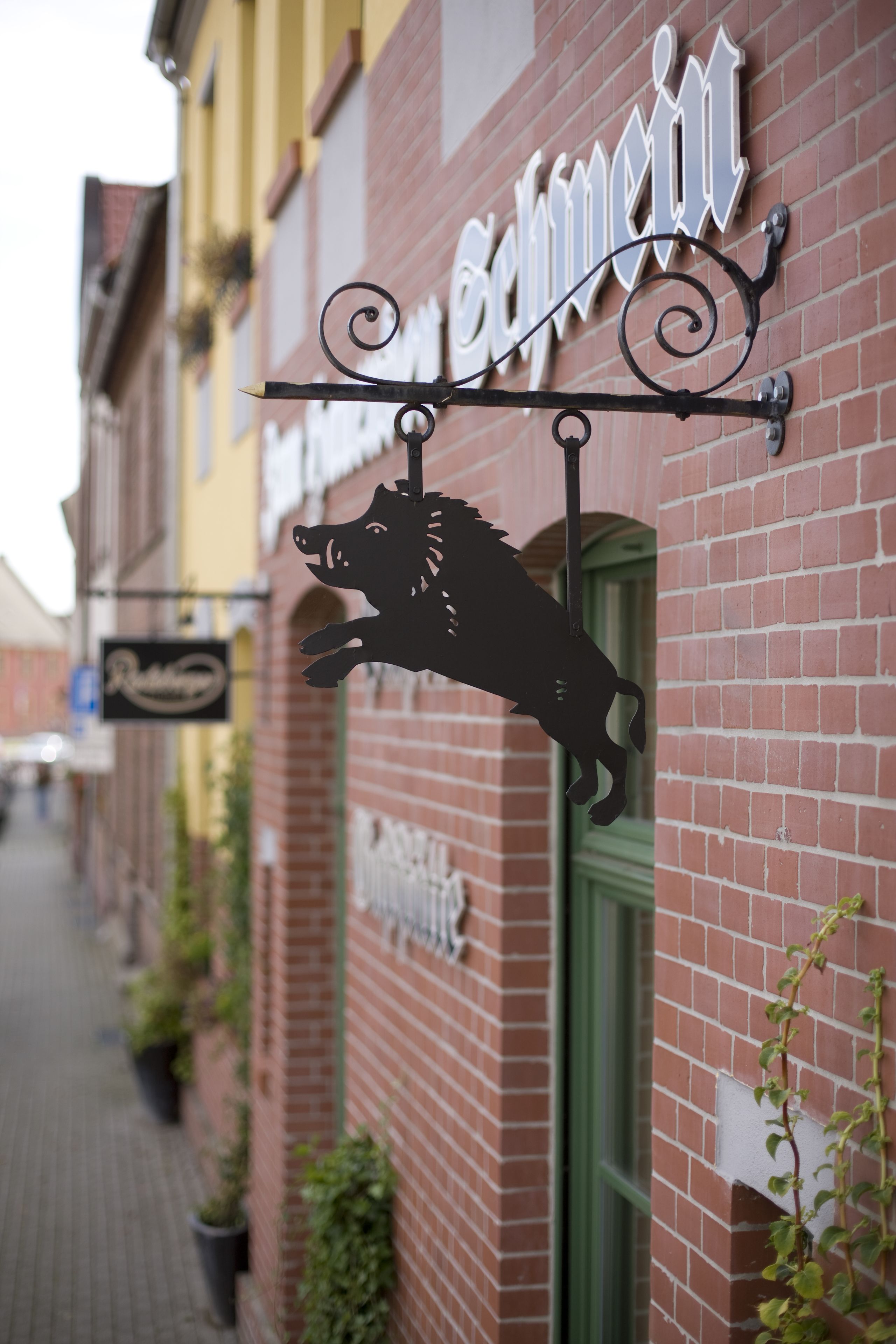 Rakennuksessa on metallinen kyltti, jossa on härän pää ja teksti ”Schwein”.