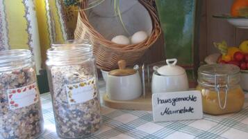 A table with jars of food, a basket of eggs, and a sign indicating 'Hausgemachte Marmelade'.