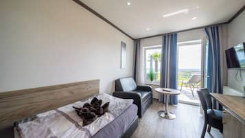 Una habitación de hotel moderna con cama, escritorio, silla y televisor.