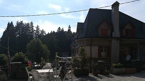 A building with a steep roof, a chimney, and a balcony with potted plants. - B&B Brunate Kangucavallo (Brunate)