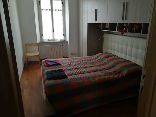 A bedroom with a bed, a chair, a radiator, and a window. - B&B Brunate Kangucavallo (Brunate)