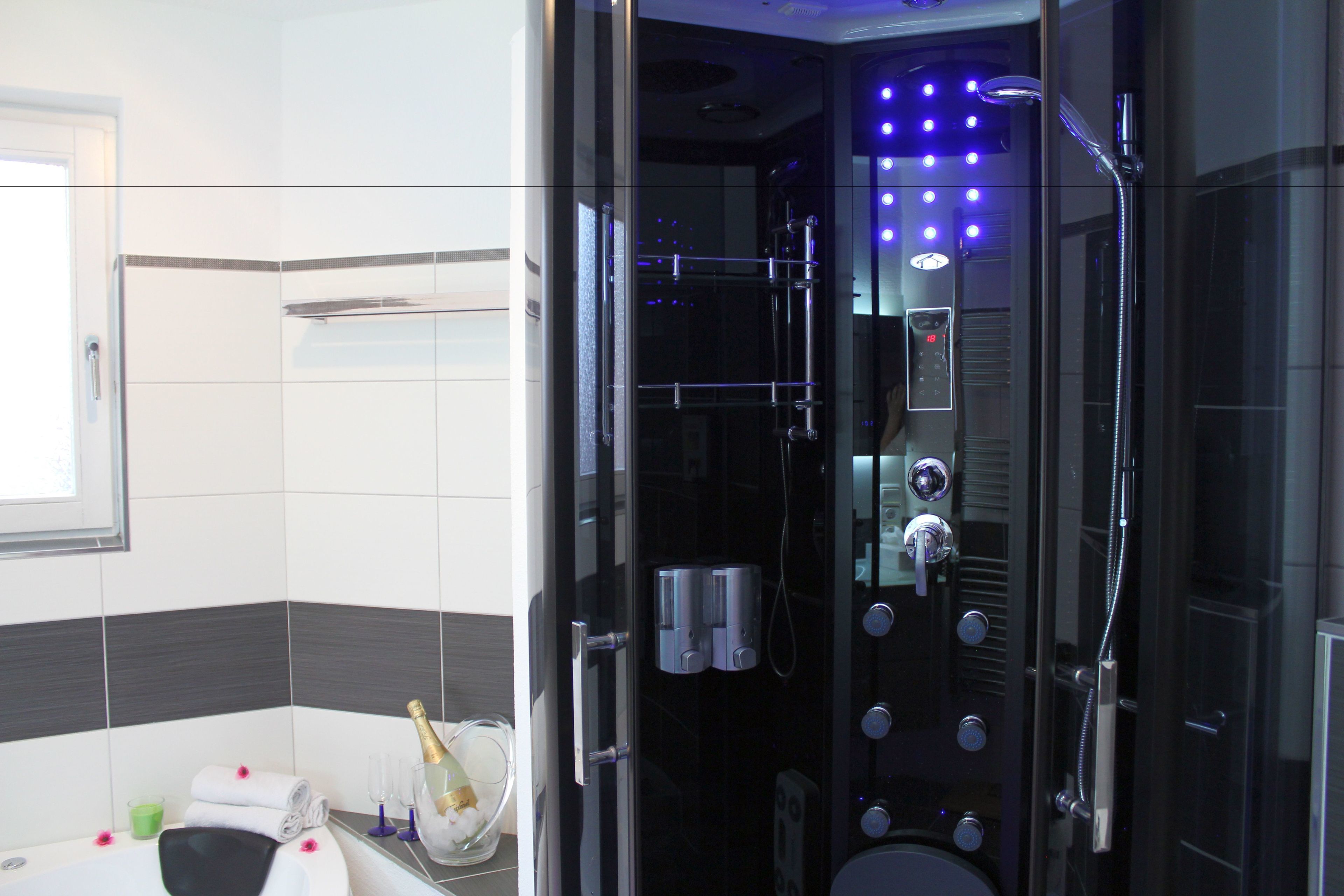 Une salle de bain moderne avec une douche à parois de verre, des toilettes et une baignoire.