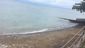 Une plage avec une eau cristalline et des bateaux visibles au loin.
