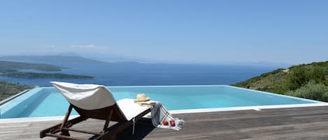 Piscine extérieure, parasols de plage, chaises longues