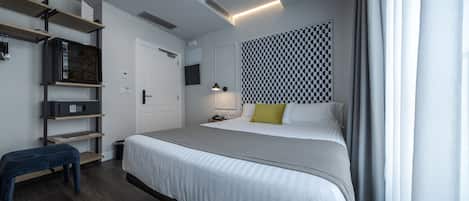 Un dormitorio moderno con una cama grande, un banco, un televisor y una pared con diseño.
