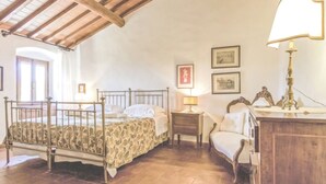 Un dormitorio con una cama con dosel, un armario de madera, una mesita de noche y una silla.