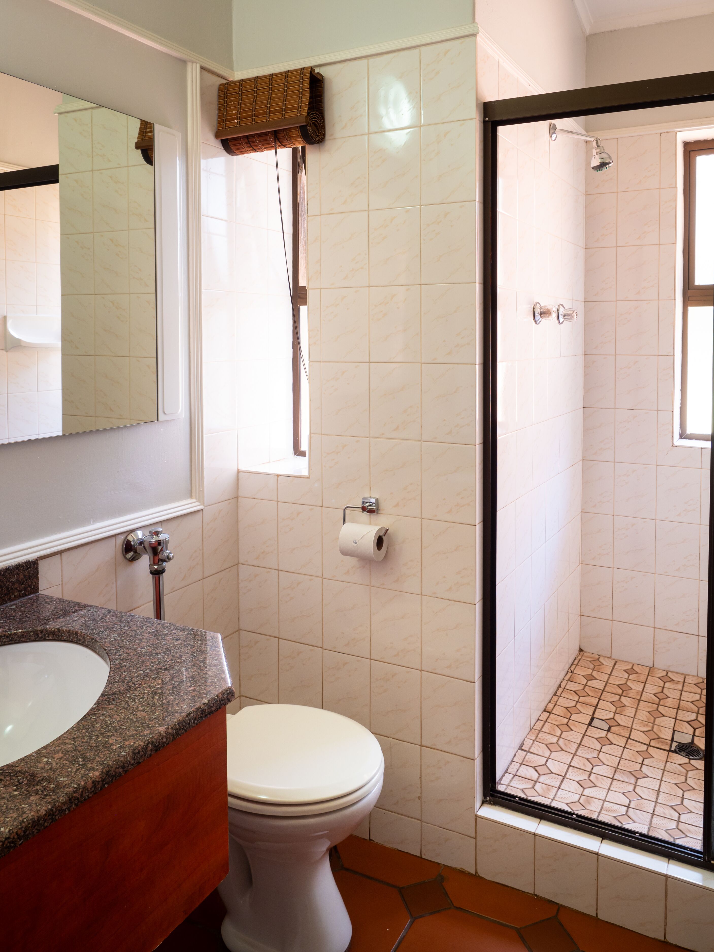 A bathroom with a toilet, sink, and shower.