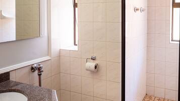 A bathroom with a toilet, sink, and shower.