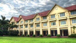 A multi-story hotel with a symmetrical facade, large windows, and a red-tiled roof. - Country Roads (Uluberiya)