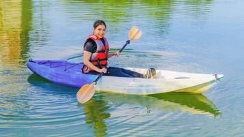 A person in a kayak on calm water.