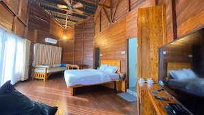 Una habitación de madera con una cama, un televisor y un escritorio.
