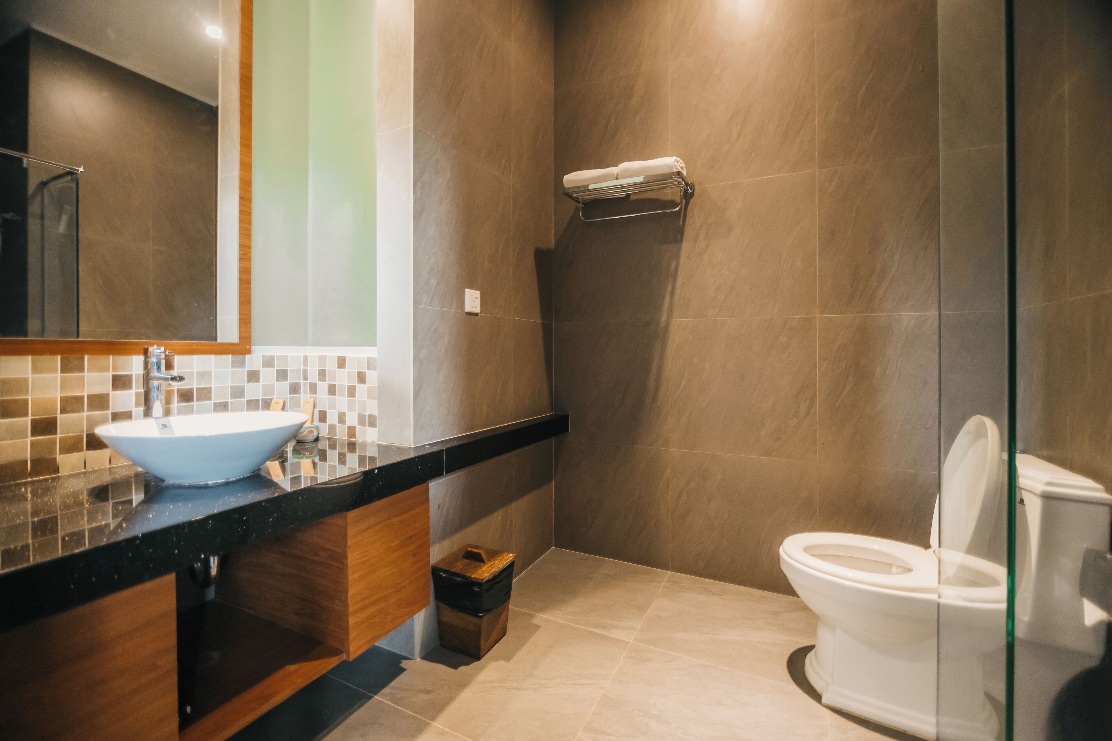 Une salle de bain moderne avec un grand miroir, un lavabo et des toilettes.