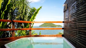 A wooden deck with a rectangular pool, surrounded by tropical plants and a wooden railing. - Chalé Jaguanum (Mangaratiba)