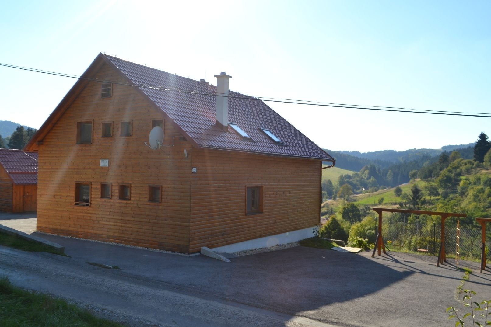 Una casa di legno con tetto spiovente, diverse finestre e un'antenna parabolica.