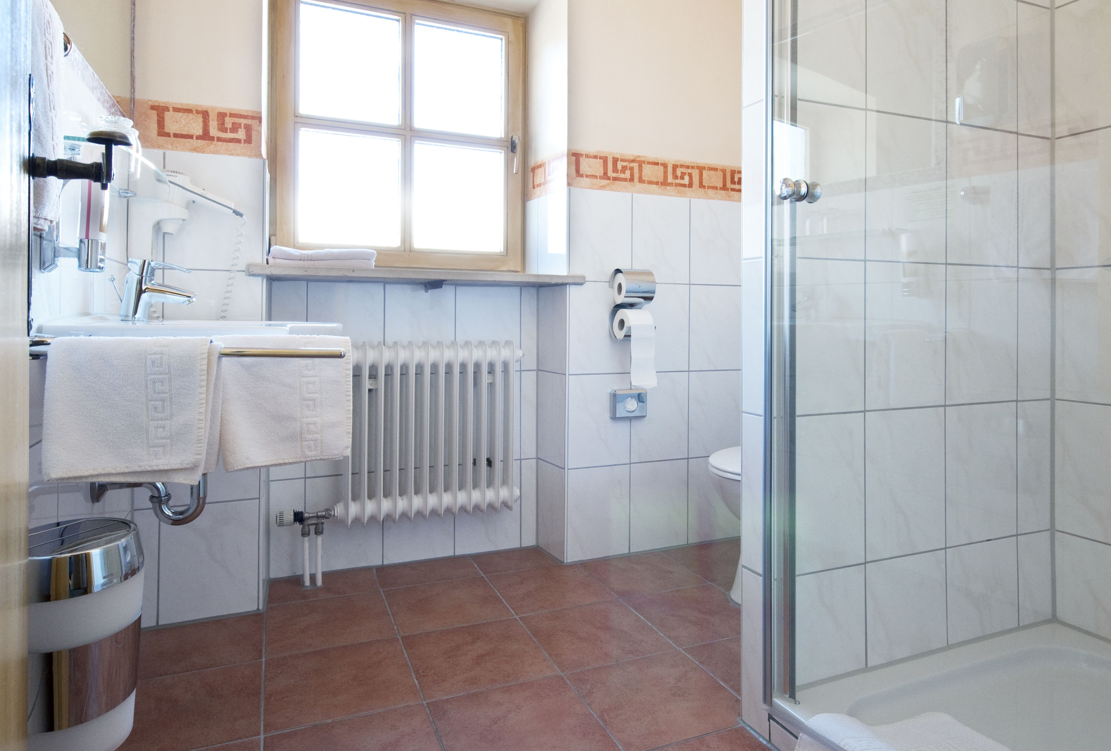 A bathroom with a shower, toilet, and sink.