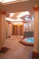 Un hall de hotel con una fuente central, columnas y una estatua.