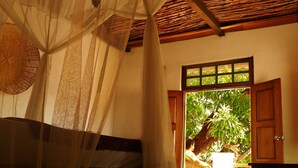 A room with a high ceiling, a woven ceiling, a large window, and a view of the outdoors. - Miti Miwiri (Ibo)