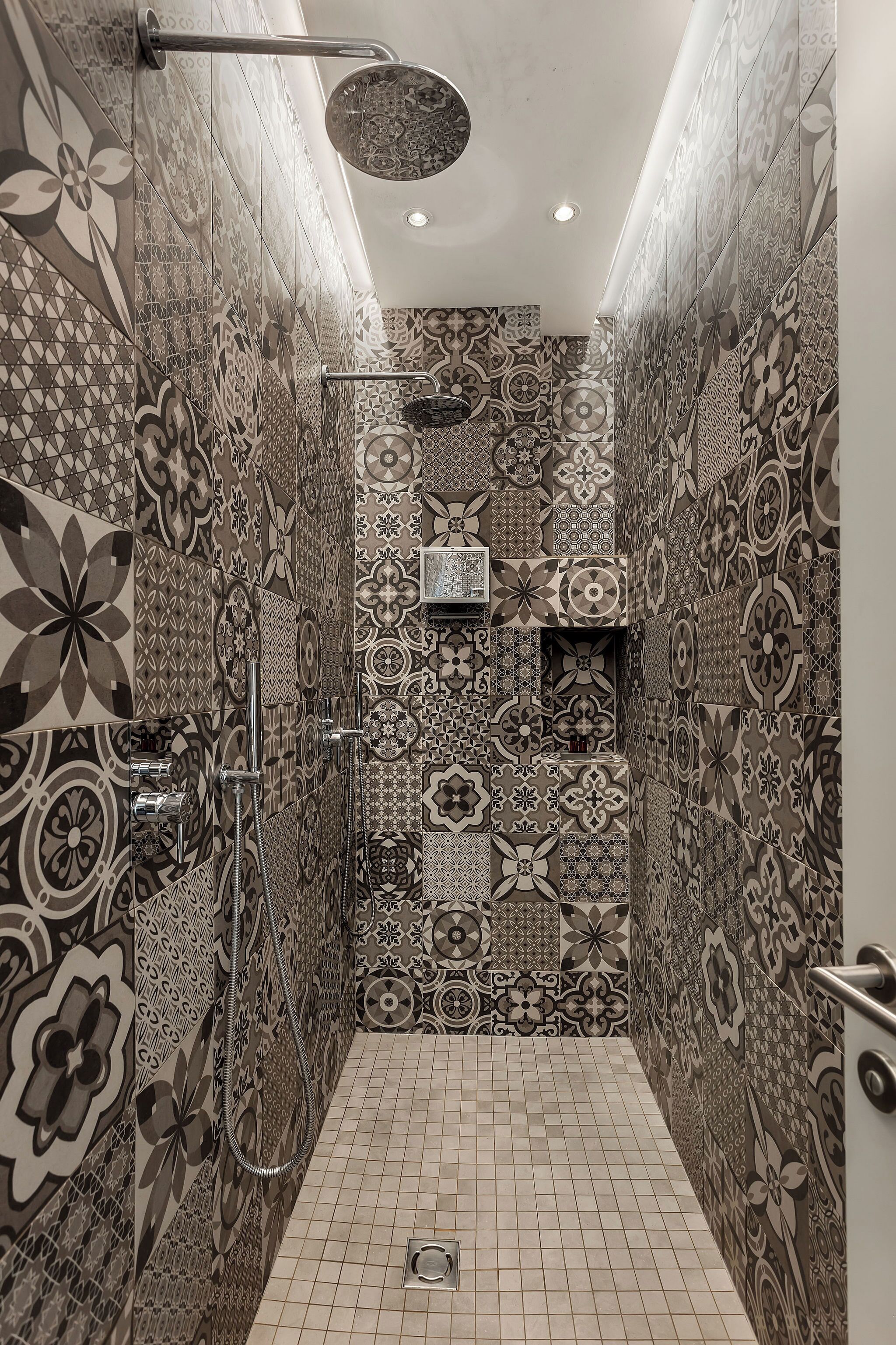 A shower with a handheld showerhead and a wall-mounted faucet.