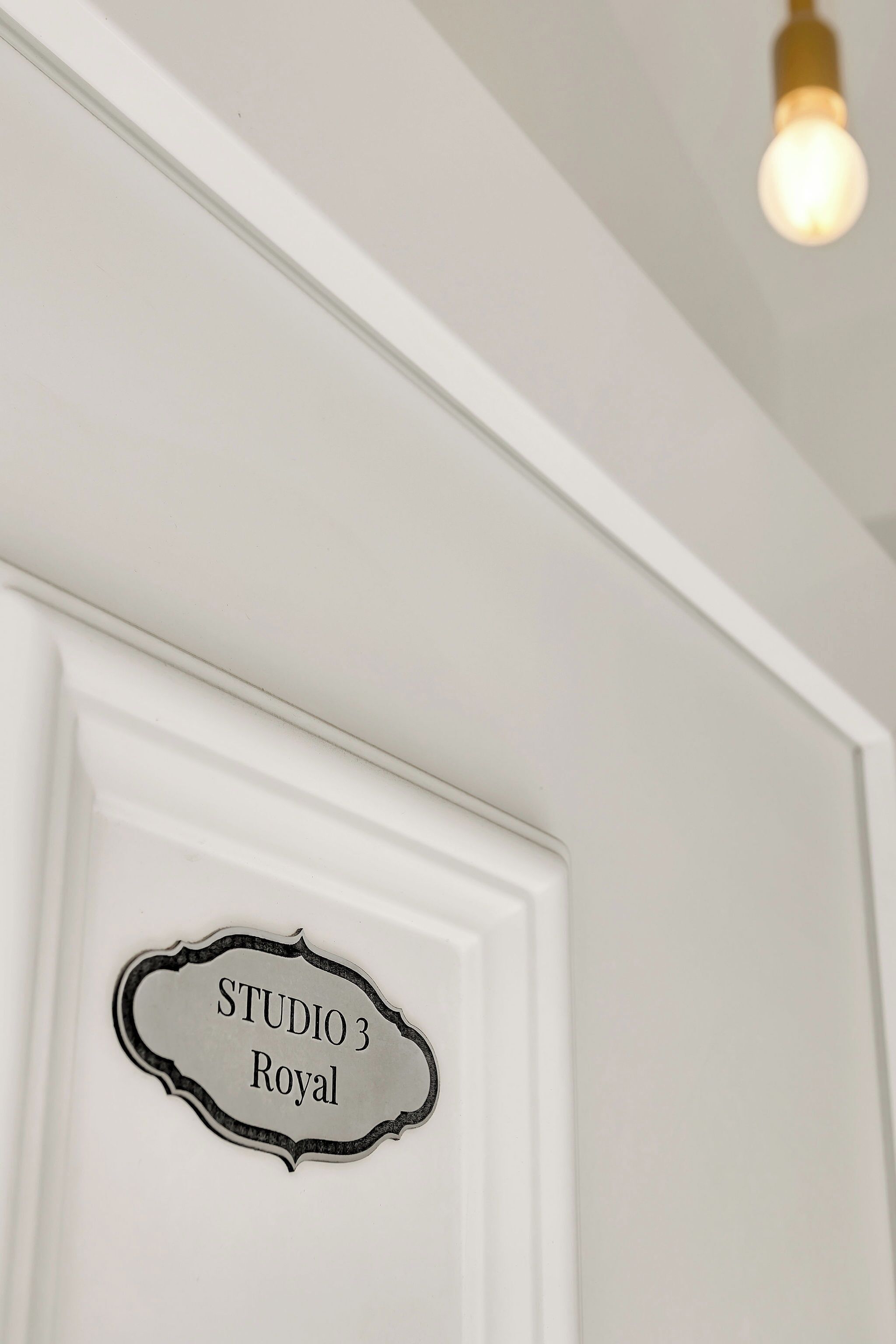 A white door with a sign that reads "STUDIO 3 Royal".