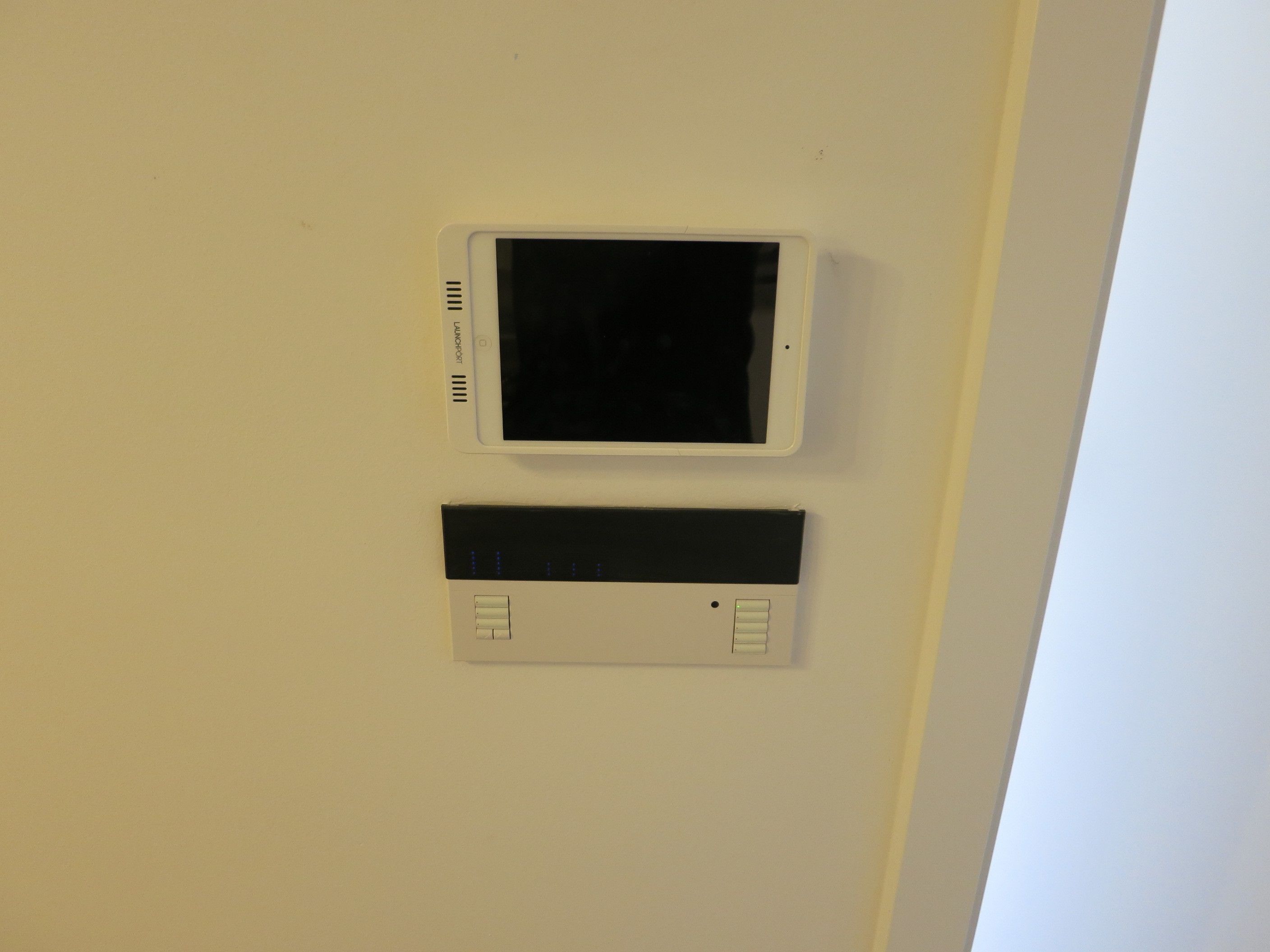 Deux appareils fixés au mur, l’un doté d’un écran et l’autre de boutons, probablement utilisés pour contrôler les fonctions de la pièce.