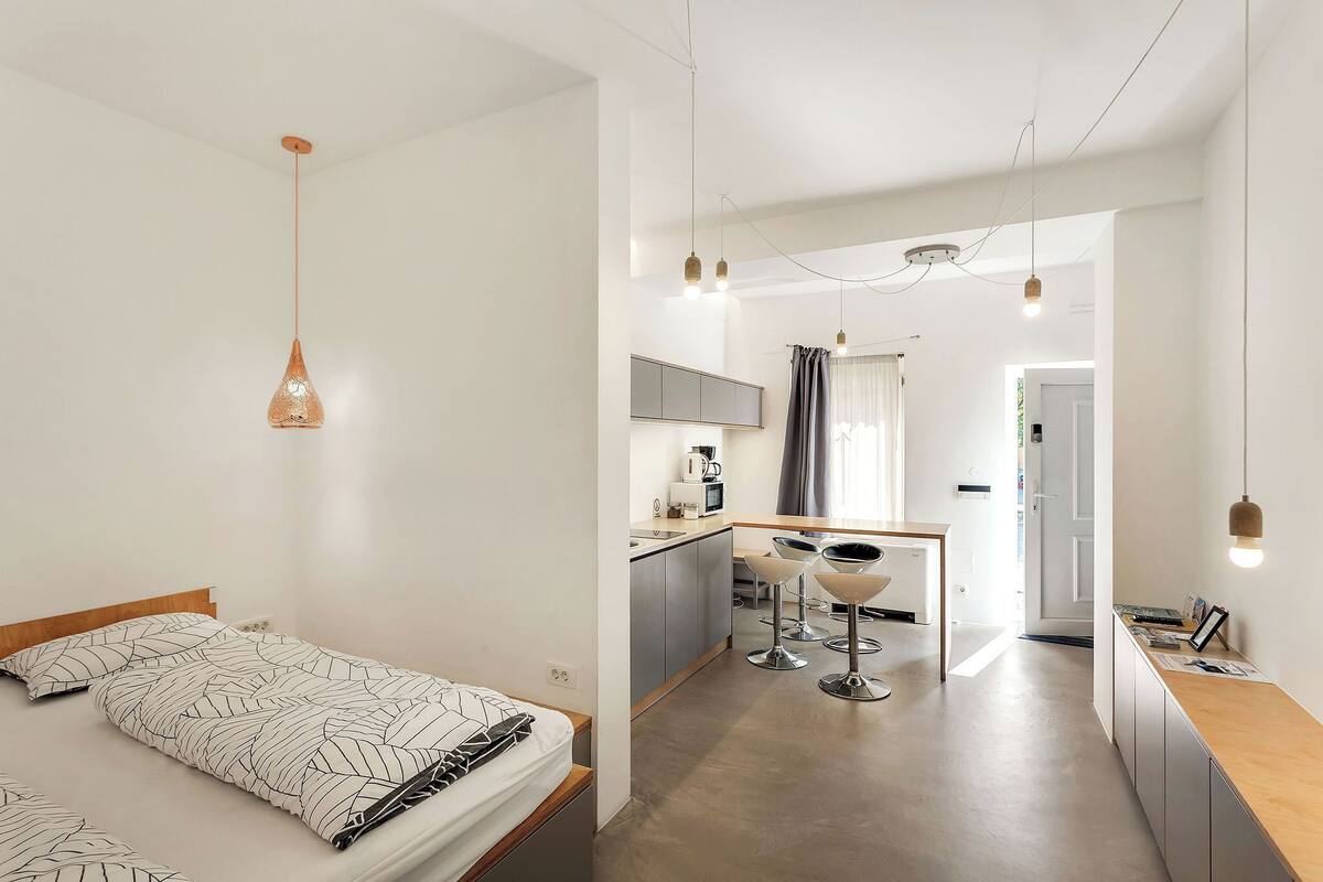 Une chambre d’hôtel moderne équipée d’un lit, d’une kitchenette et d’un coin repas.