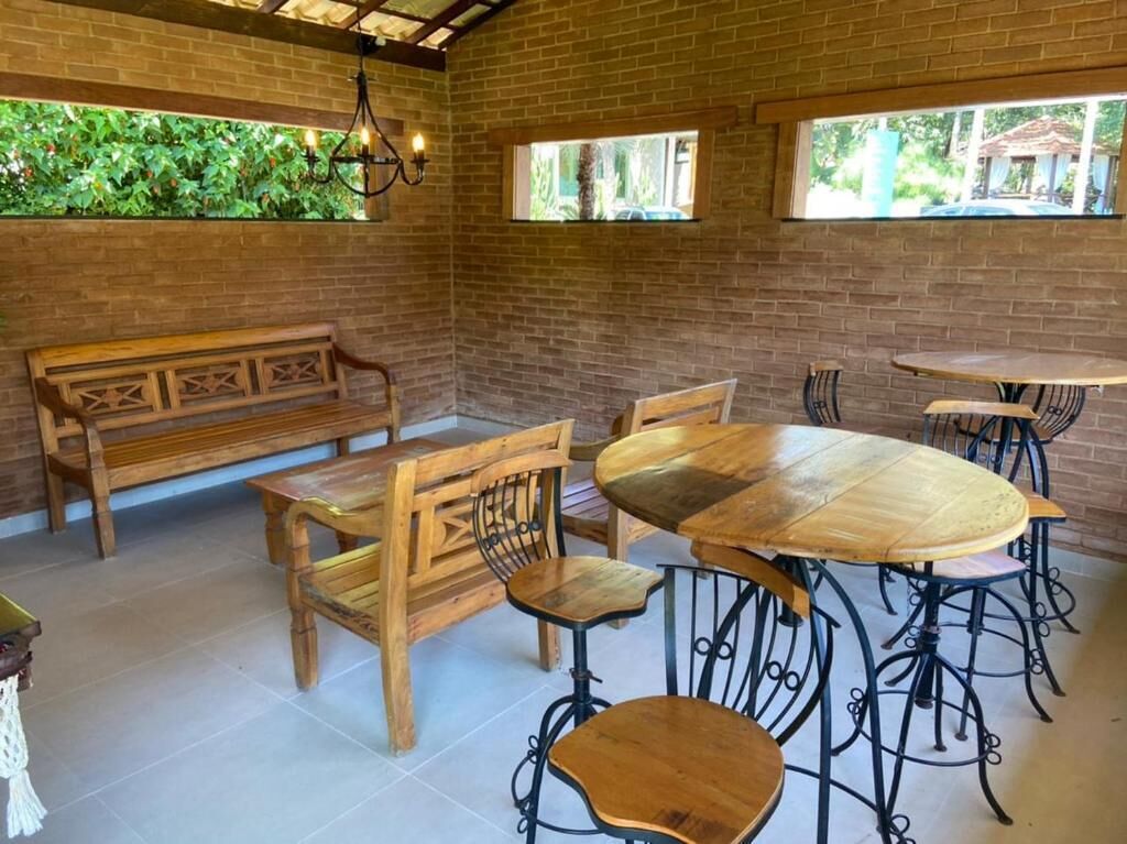 A rustic cafe with wooden furniture, brick walls, and large windows.