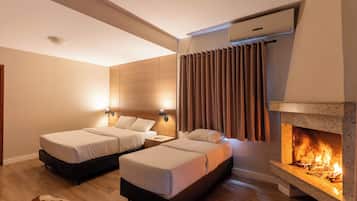 A hotel room with two beds, a fireplace, and a modern design.