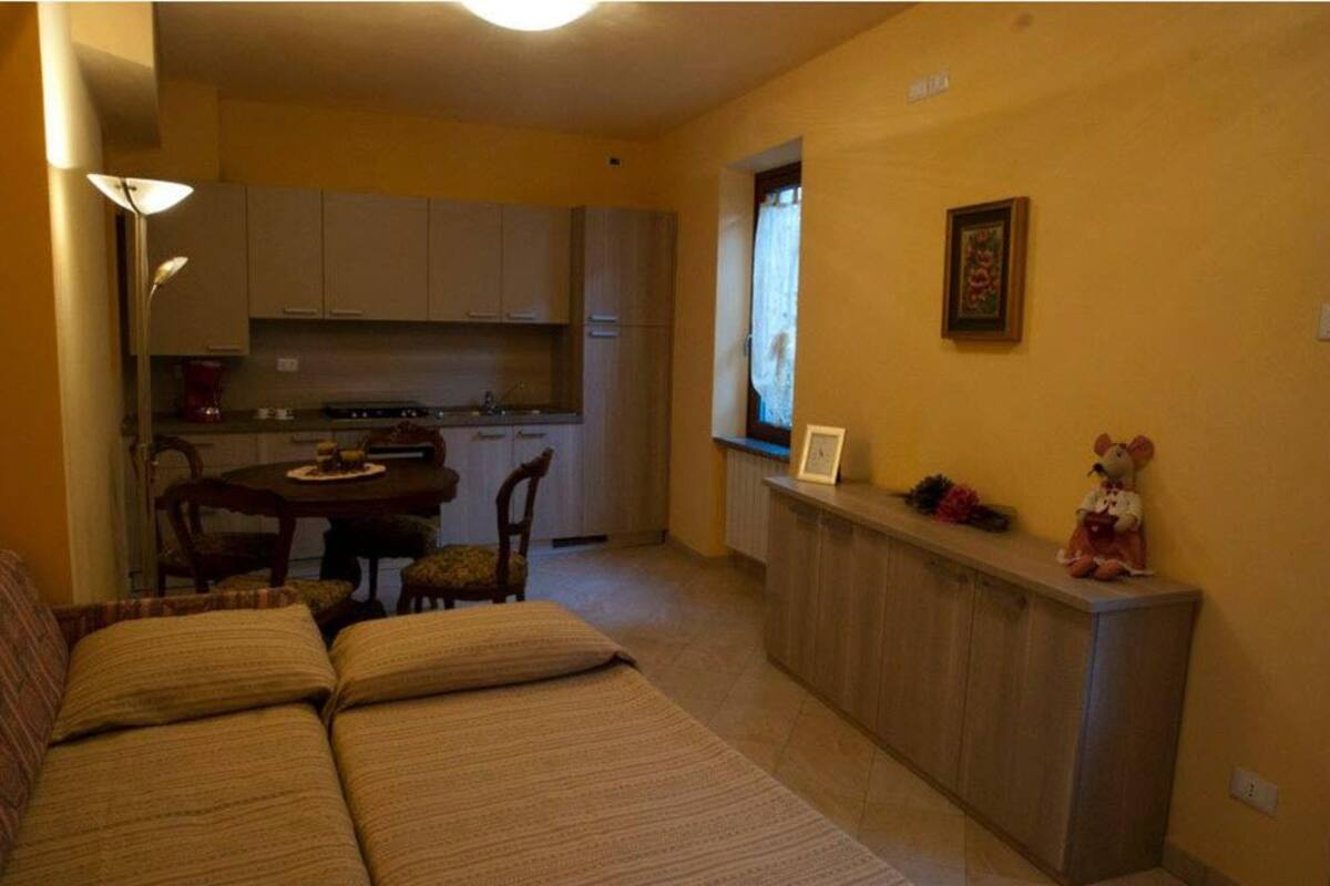 A compact living space with a kitchenette, a dining area, and a sofa.