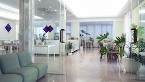 Um hall de hotel espaçoso e moderno, com balcão de recepção, área de estar e espaço para refeições.